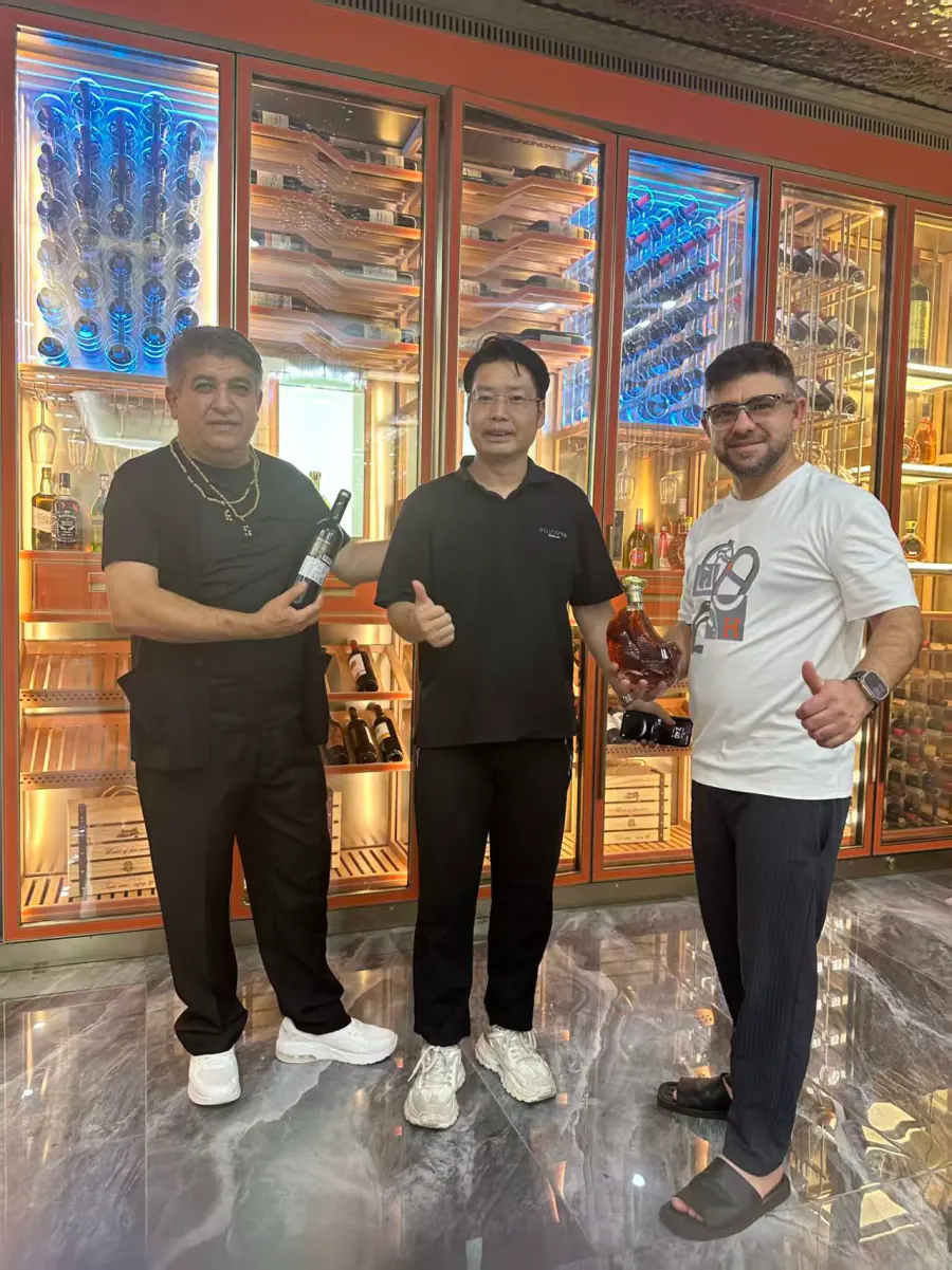 Clients visiting in front of a finished wine wall