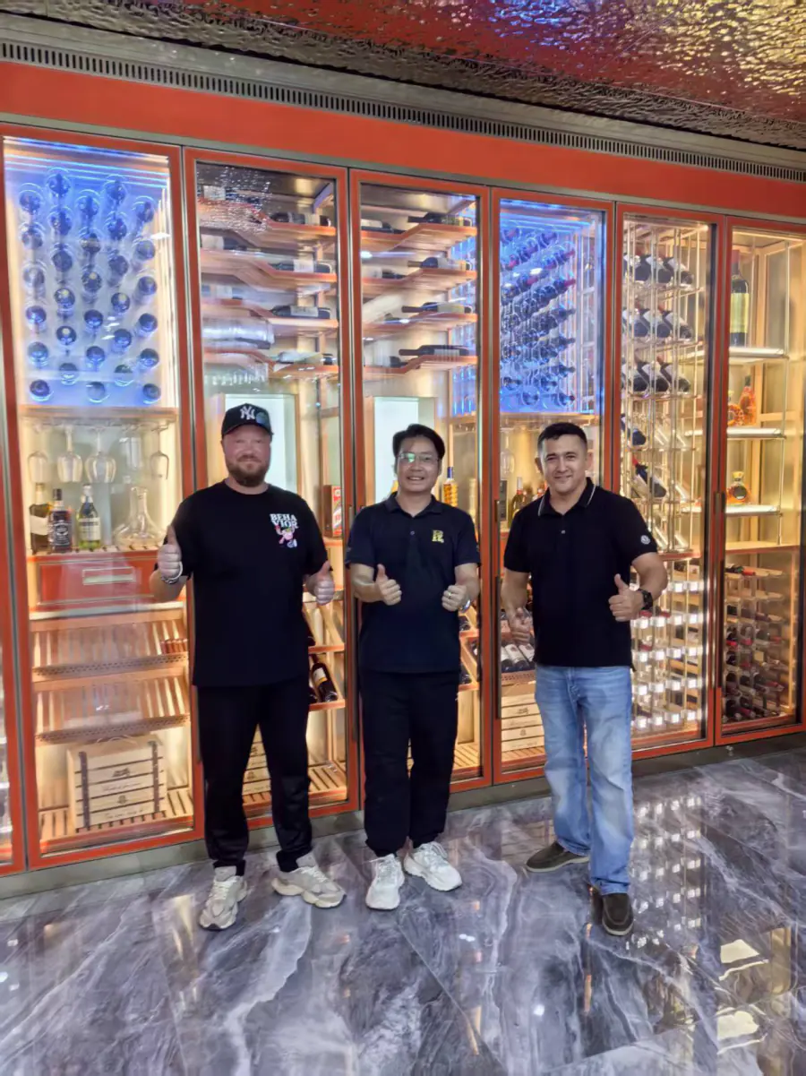 Clients visiting in front of a finished wine wall