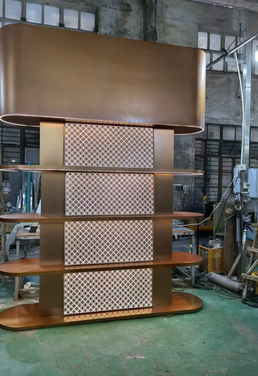 Bronze finish stainless steel bar display unit with perforated panels and curved shelves